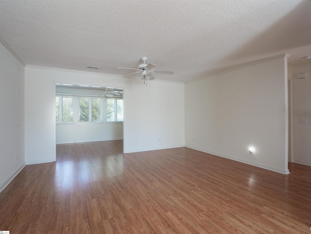 unfurnished room with a ceiling fan, a textured ceiling, ornamental molding, and wood finished floors