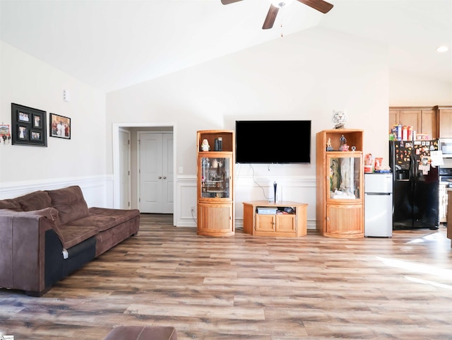 living room with ceiling fan, lofted ceiling, and light hardwood / wood-style floors