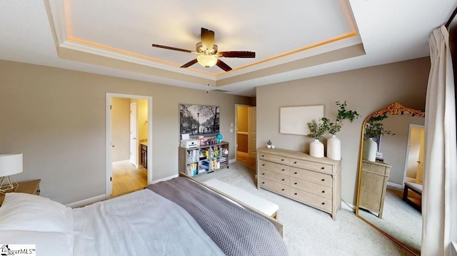 carpeted bedroom featuring ceiling fan, a tray ceiling, and crown molding