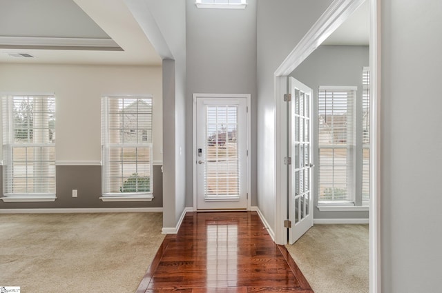 doorway to outside with a wealth of natural light and dark colored carpet