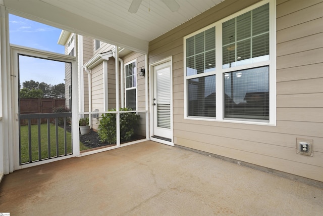 unfurnished sunroom with ceiling fan