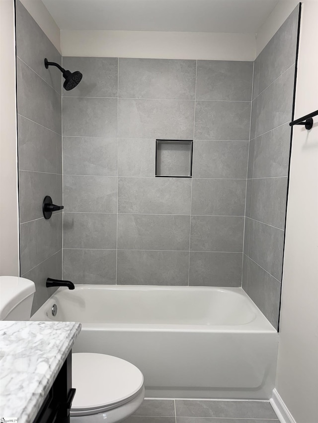 full bathroom featuring tiled shower / bath combo, vanity, and toilet