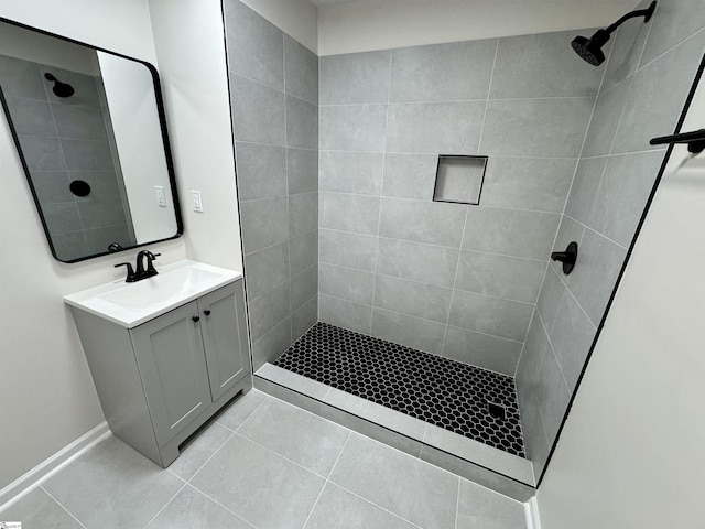bathroom with vanity, a tile shower, and tile patterned floors