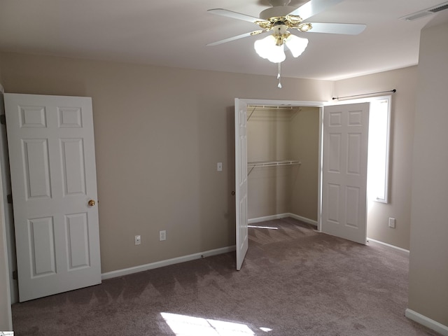 unfurnished bedroom featuring dark carpet, ceiling fan, and a closet