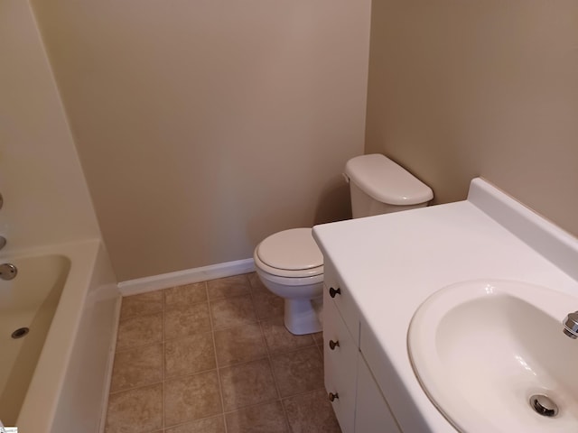 bathroom featuring a tub, tile patterned floors, vanity, and toilet