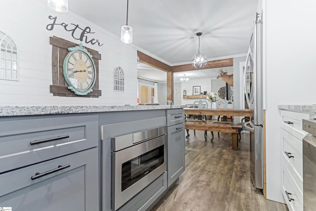 kitchen featuring pendant lighting, gray cabinetry, appliances with stainless steel finishes, and ornamental molding