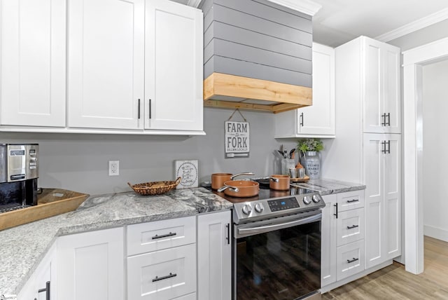 kitchen with white cabinets, premium range hood, electric stove, and light stone counters