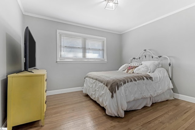 bedroom featuring ornamental molding and hardwood / wood-style floors