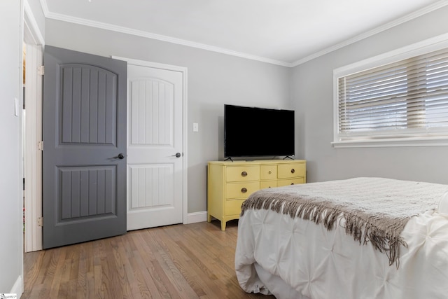 bedroom with hardwood / wood-style flooring and crown molding