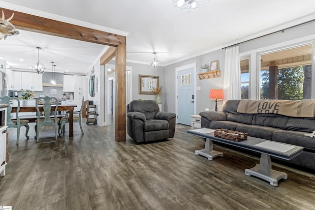 living room featuring ornamental molding, a chandelier, and dark hardwood / wood-style flooring