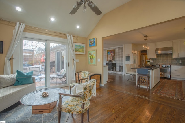 living room featuring ceiling fan, vaulted ceiling, dark hardwood / wood-style flooring, and a fireplace