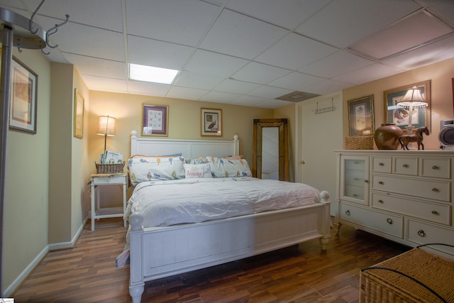 bedroom featuring a paneled ceiling and dark hardwood / wood-style floors