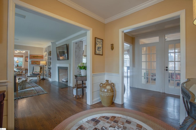 foyer with dark wood-type flooring, crown molding, and french doors