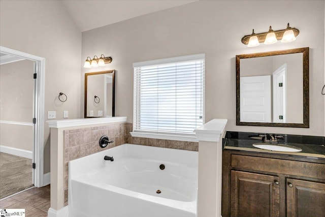 bathroom with tile patterned flooring, vanity, a bathtub, and lofted ceiling