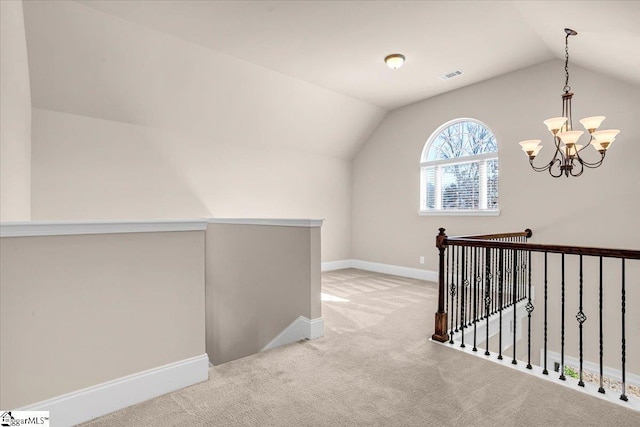 hallway with light carpet, lofted ceiling, and an inviting chandelier