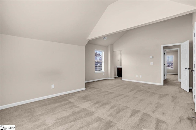 interior space with high vaulted ceiling and light colored carpet