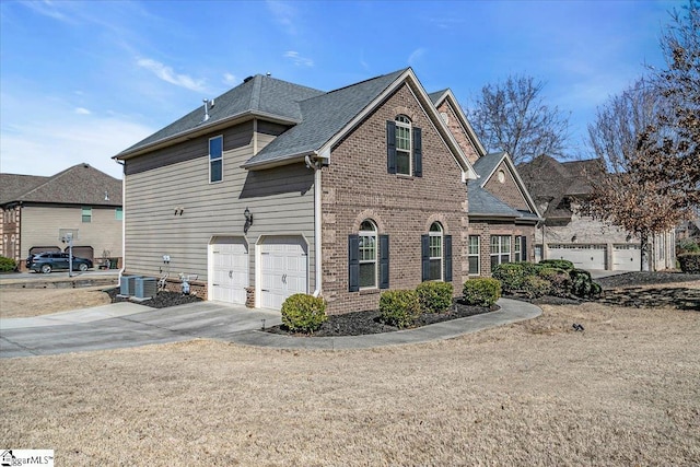 view of front of home with a garage and central AC