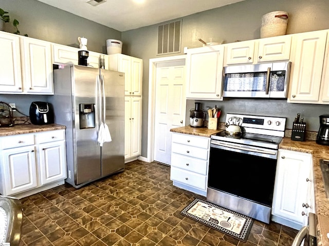 kitchen with appliances with stainless steel finishes and white cabinetry