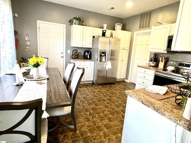 kitchen with appliances with stainless steel finishes and white cabinets