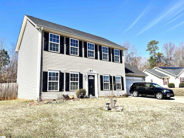 colonial house with a front yard and a garage