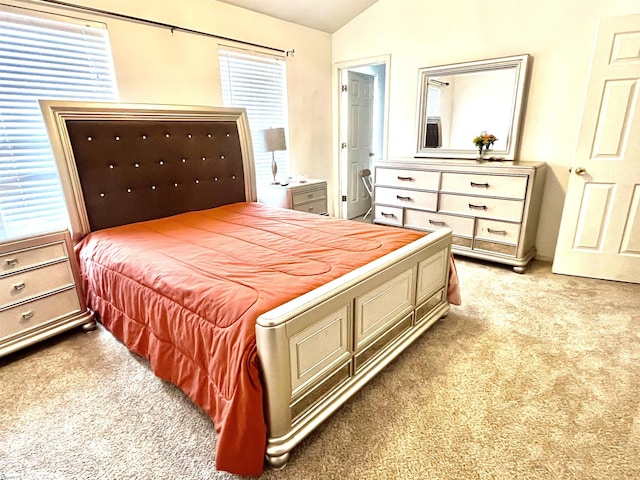 bedroom with light carpet and lofted ceiling