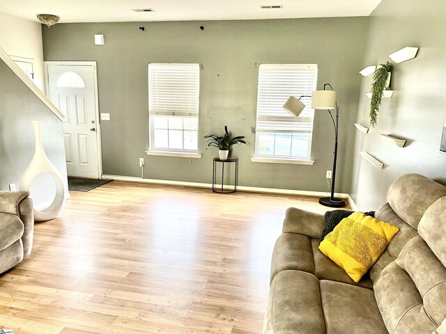 living room with visible vents, baseboards, plenty of natural light, and light wood-style floors
