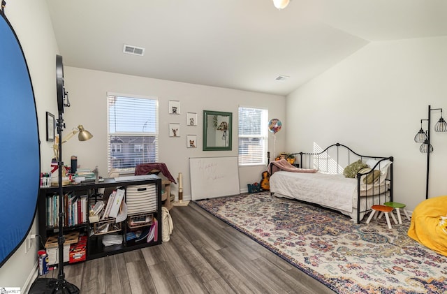 bedroom with hardwood / wood-style floors, multiple windows, and vaulted ceiling