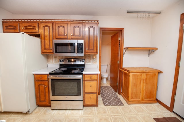 kitchen with stainless steel appliances and decorative backsplash