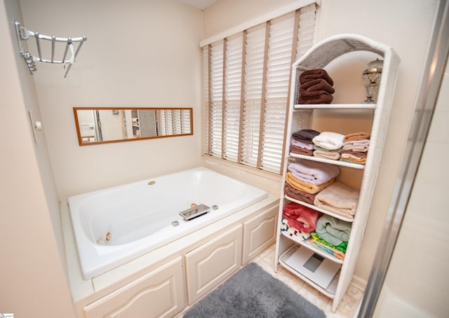 bathroom with a tub to relax in and tile patterned flooring