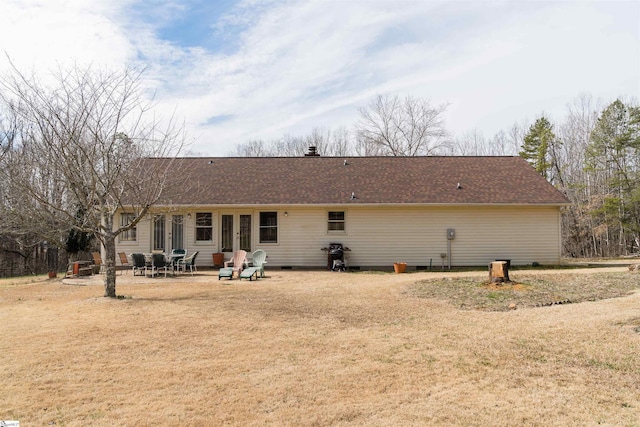 rear view of property with a yard and a patio area