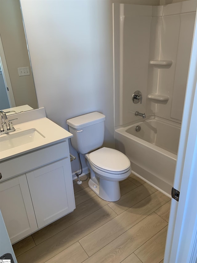 bathroom with toilet, vanity, shower / tub combination, and wood finished floors