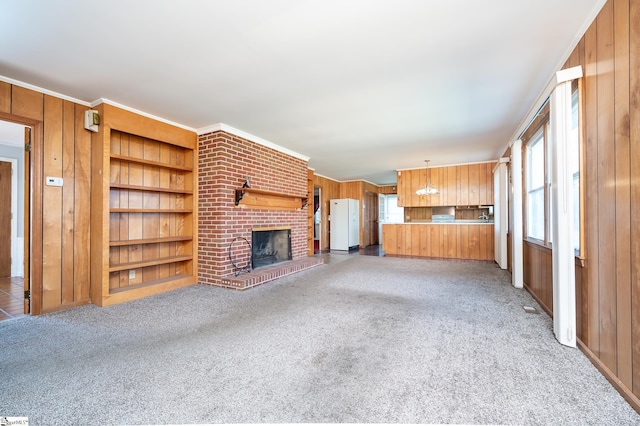 unfurnished living room featuring built in features, carpet flooring, and plenty of natural light