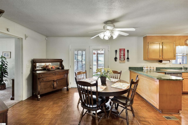 dining area with a textured ceiling, dark parquet floors, french doors, and a wealth of natural light