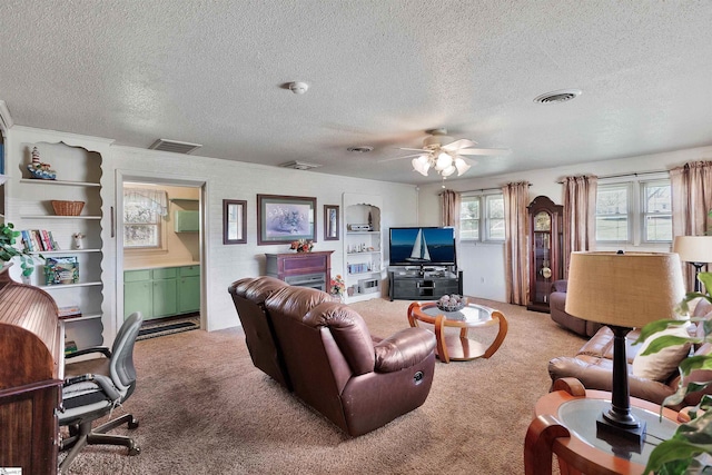 carpeted living room with ceiling fan and a textured ceiling