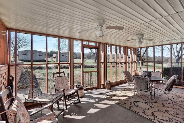 unfurnished sunroom with ceiling fan