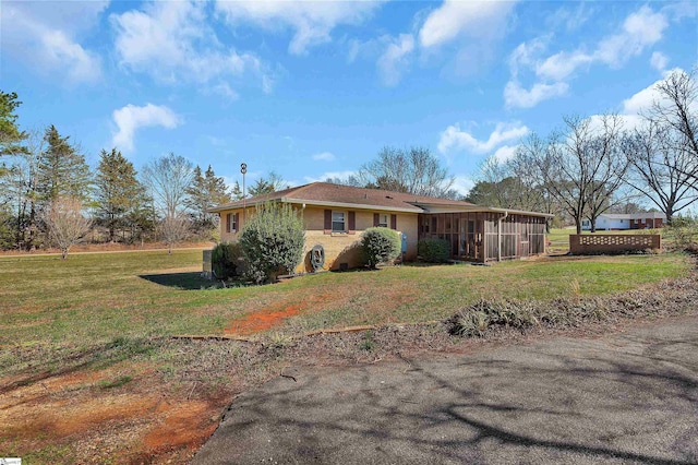 view of front of home featuring a front yard and a sunroom