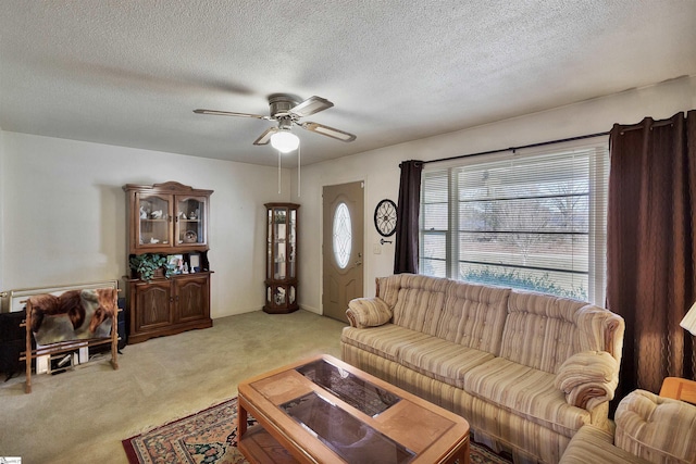 living room featuring ceiling fan, light carpet, and a textured ceiling