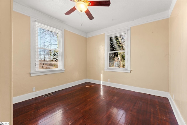 empty room featuring ceiling fan, plenty of natural light, wood-type flooring, and ornamental molding