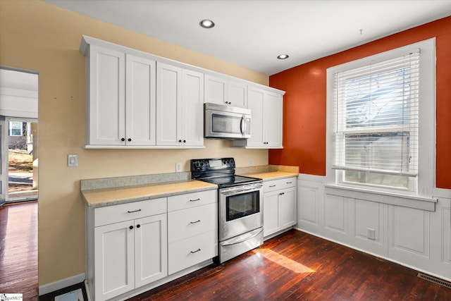 kitchen featuring white cabinetry, appliances with stainless steel finishes, and dark hardwood / wood-style floors