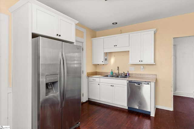 kitchen featuring white cabinets, appliances with stainless steel finishes, sink, and dark wood-type flooring