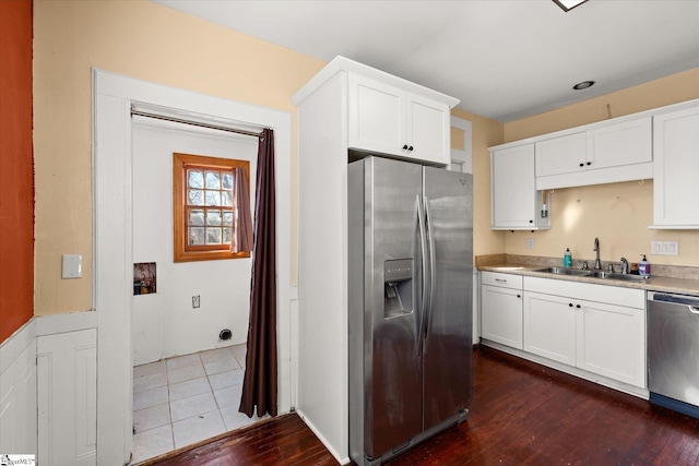 kitchen with white cabinets, appliances with stainless steel finishes, sink, and dark hardwood / wood-style flooring