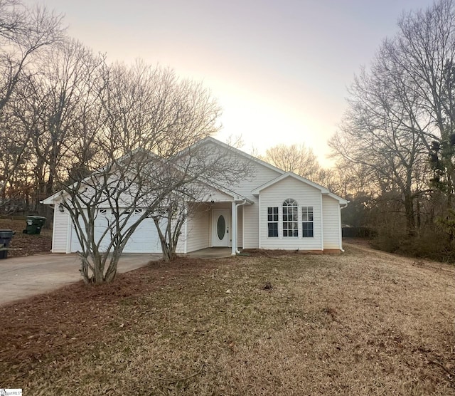 ranch-style home with a garage and a yard