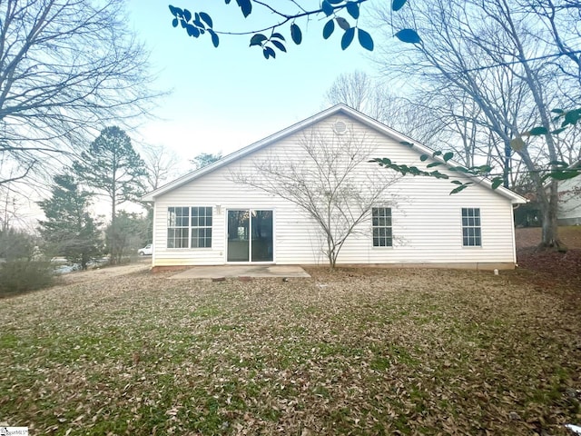 back of property with a patio area and a yard