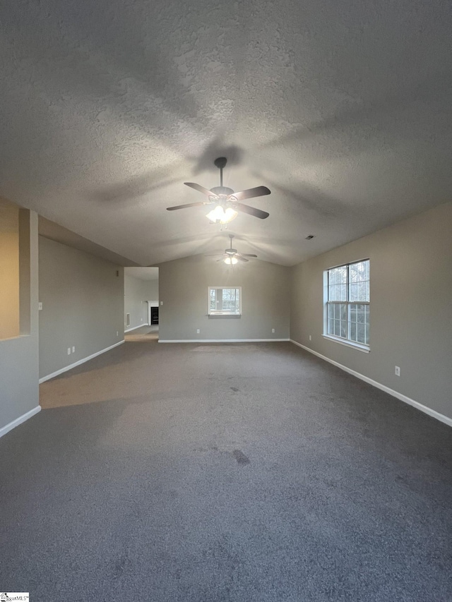 unfurnished living room with a textured ceiling, vaulted ceiling, carpet flooring, and ceiling fan