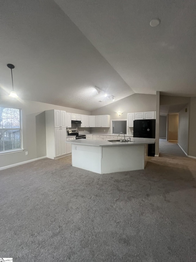 kitchen featuring white cabinetry, stainless steel range with electric stovetop, lofted ceiling, and an island with sink