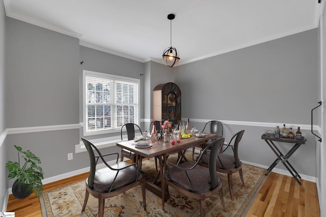 dining area with hardwood / wood-style flooring and ornamental molding