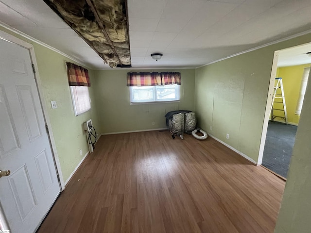 empty room with hardwood / wood-style flooring and crown molding