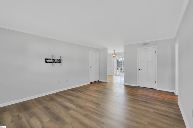 unfurnished room featuring dark hardwood / wood-style flooring, ornamental molding, and a chandelier