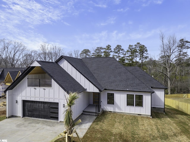 modern inspired farmhouse with a garage and a front lawn