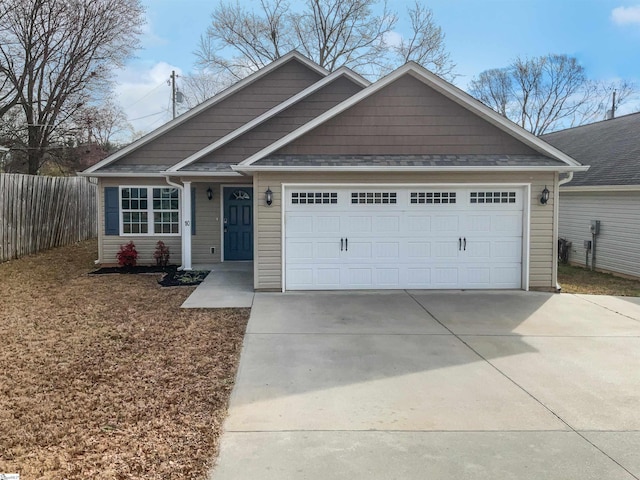 view of front of house featuring a garage, driveway, and fence